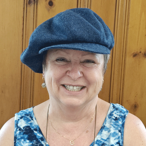 happy student wearing blue tweed poor boy cap