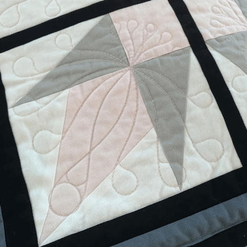 ruler-quilted corner motif on pieced quilt