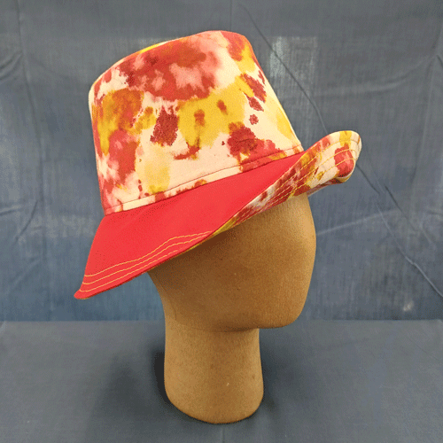 a sunny, sassy bucket hat in a red, orange, and yellow abstract print with red contrasts