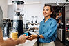 female-coffee-shop-owner-holding-a-pos-terminal-wh-min.jpg