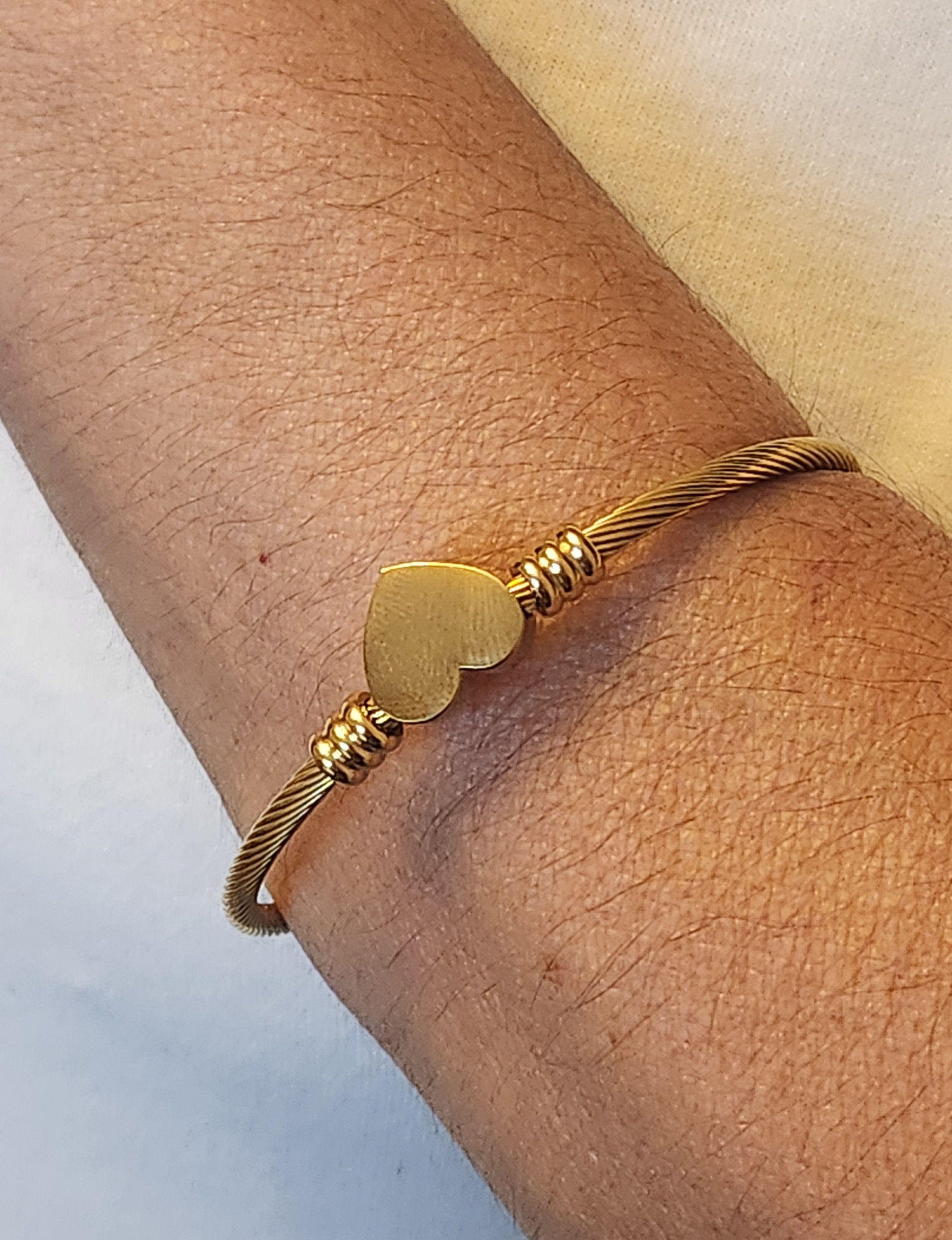 Bracelete torcido coração aço dourado.