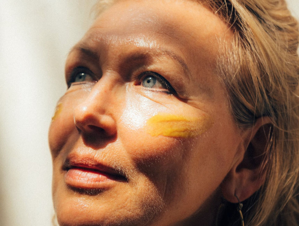 Close-up of 60-year-old woman with glowing skin and turmeric-based waterless skincare applied under her eyes, showcasing natural wrinkle-softening rituals by Star Seed.