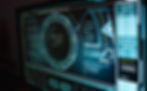 A futuristic computer screen displays complex data and diagrams with blue and black tones, creating a high-tech, analytical atmosphere.