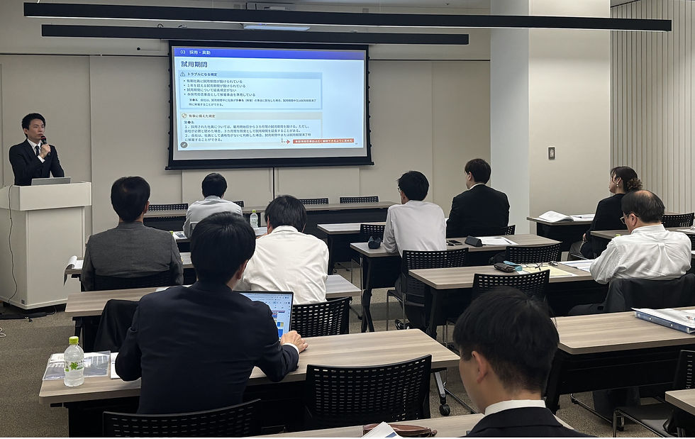 会議室でスーツ姿の講師が講演中。