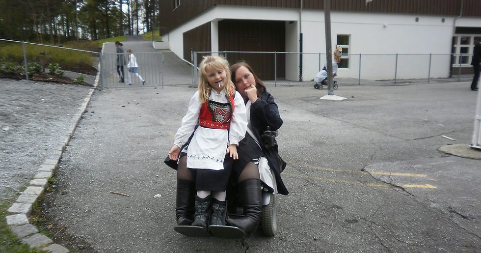 Jente sitter på fanget til mammaen sin. Mammaen sitter i rullestol.