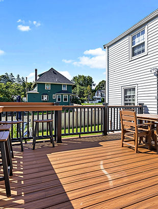 Upper deck with outdoor dining furniture and dark railings in Braintree, MA