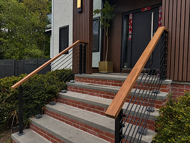 Renovated Newton front porch with wood cladding, brick steps, and black metal railings