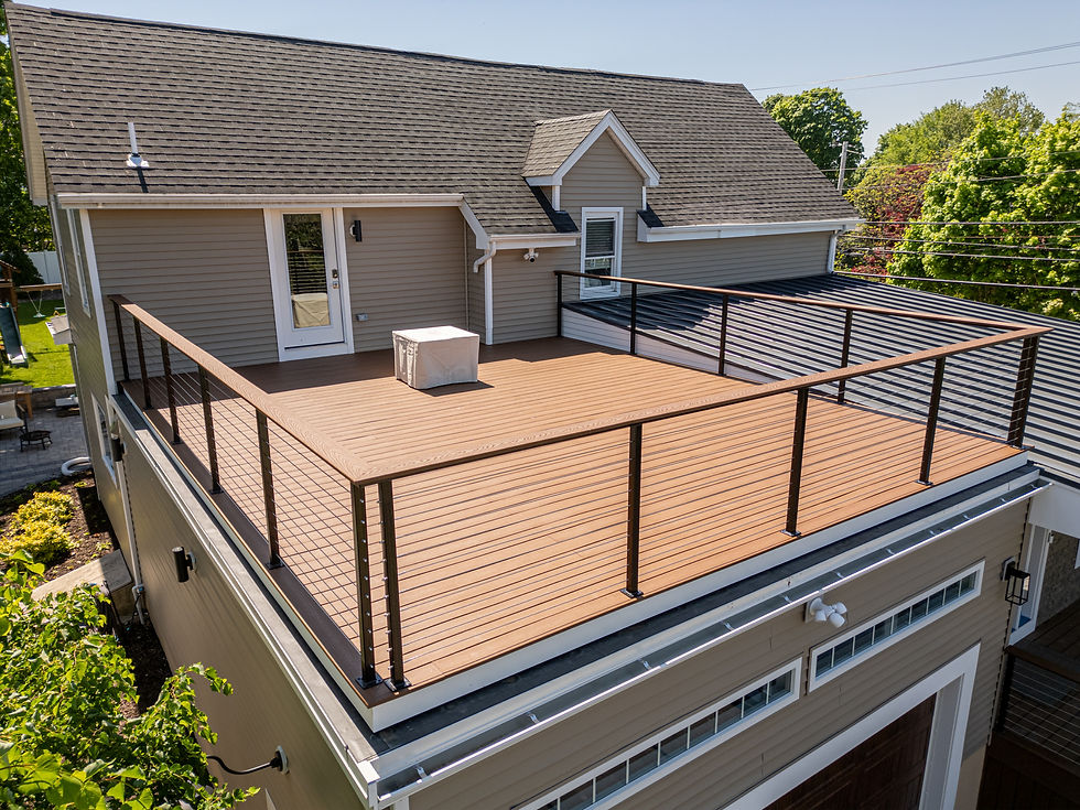 Side view of Braintree home addition showing flat roof deck with modern railing above the garage