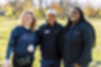Three people standing together in a garden
