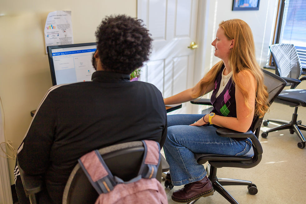 Staff providing help to a resident, both sitting and looking at a computer