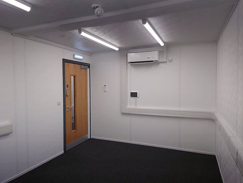 A room featuring a closed door and a wall-mounted air conditioner unit.