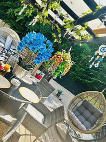 well decorated patio area with flowers and furniture