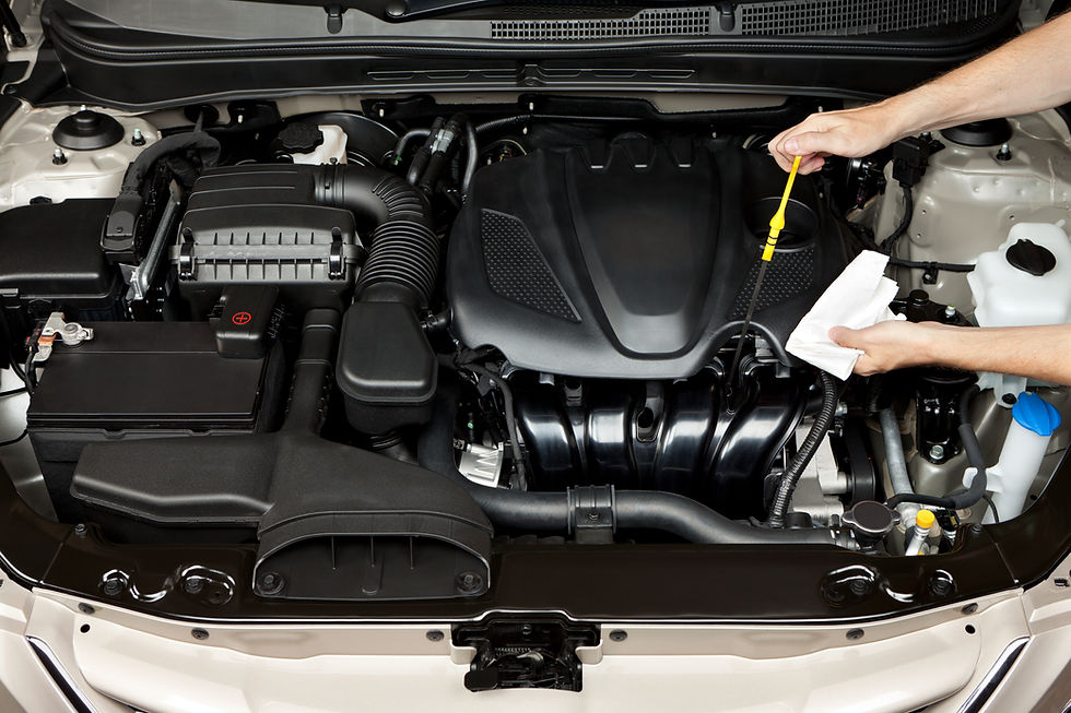 auto mechanic inspecting oil of car engine