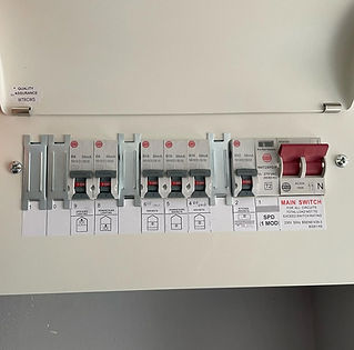 An electrical panel with multiple circuit breakers labeled with functions like lighting an