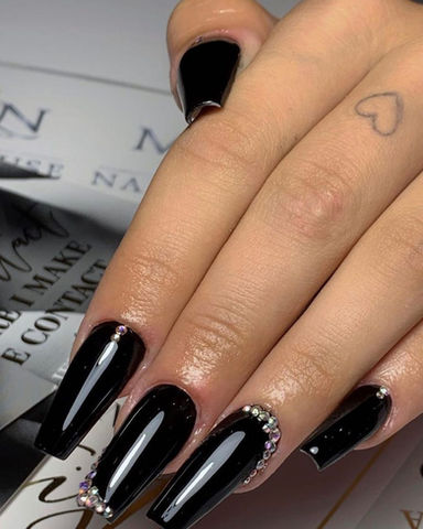Woman’s long black nails with rhinestones
