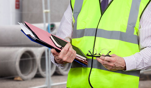 Building surveyor in high visibility vest carrying work folders