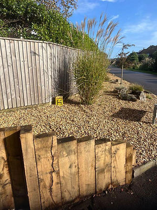 A wooden fence surrounds a gravel area