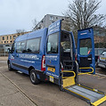 A blue van equipped with a ramp at the rear