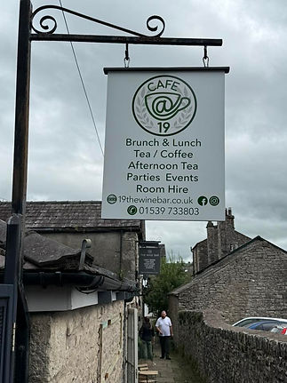 A café sign reads “Café _ 19” with offerings like brunch, lunch, and events_