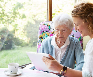 a woman showing tablet to an elder woman