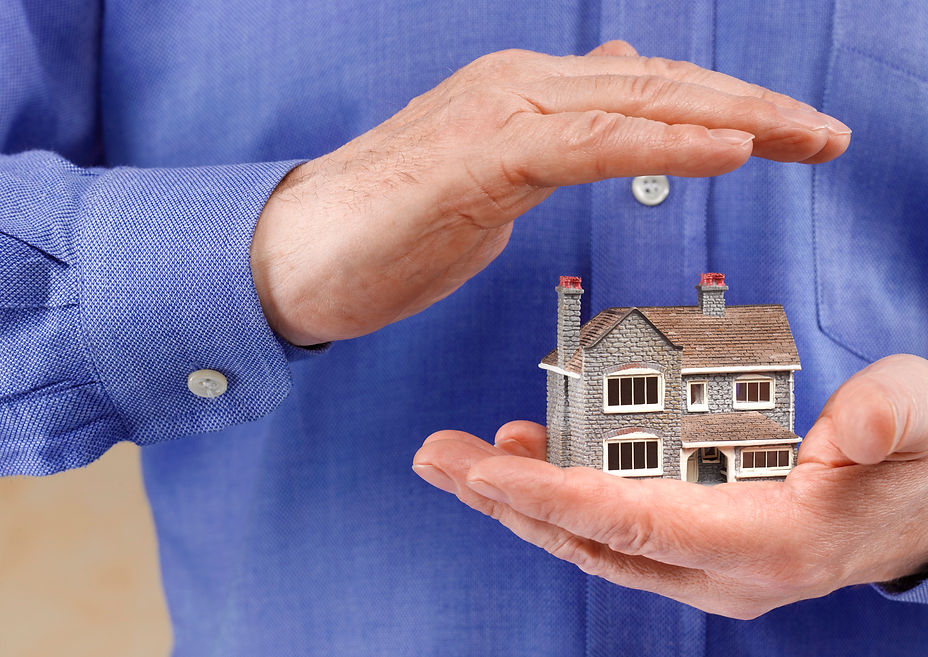 a person's hand with house model