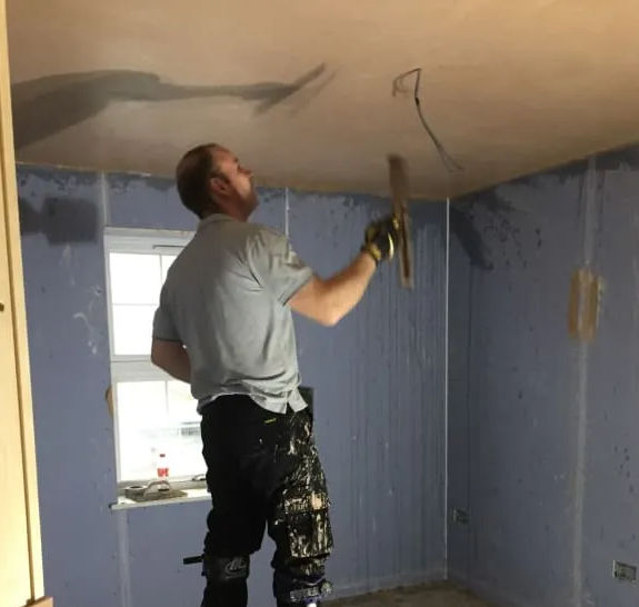 a worker plastering the ceiling