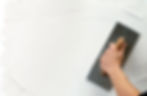 close-up image of a person's hand while using plastering trowel