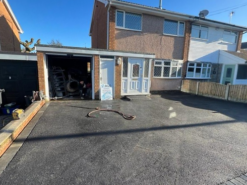 asphalt driveway of a house and open garage door