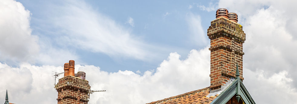 Decorative brick chimney stacks and clay pots against blue sky