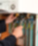 close-up image of a person's hand while repairing boiler