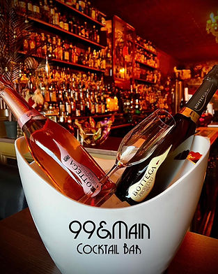A white ice bucket holds two Bottega wine bottles and a glass