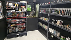 A hobby store corner with shelves displaying model kits, paint supplies, and tools