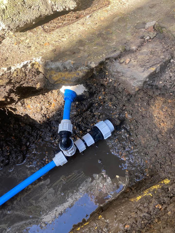 A blue pipe with white plastic fittings