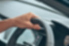 a person's hand on steering wheel