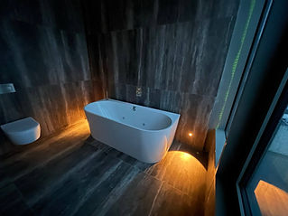 bathtub and illuminated lights in bathroom