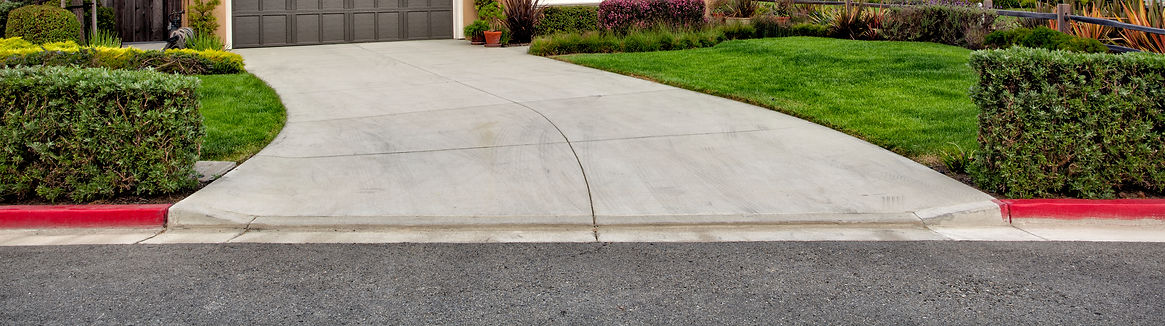 close-up image of driveway and green grass