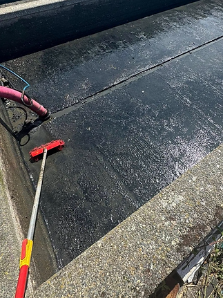 outdoor concrete settlement tank being cleaned with high pressure hoses