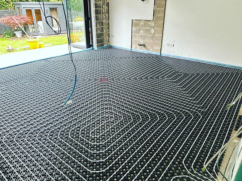 Underfloor heating system with coiled pipes installed in a room under construction