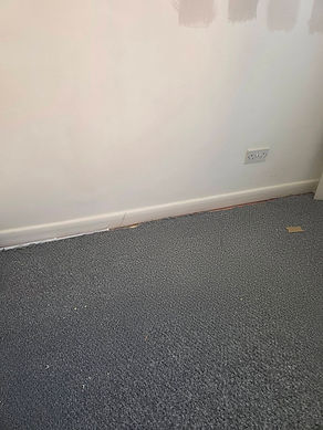 A room with a light gray wall partially painted