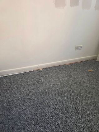 A room with a light gray wall partially painted