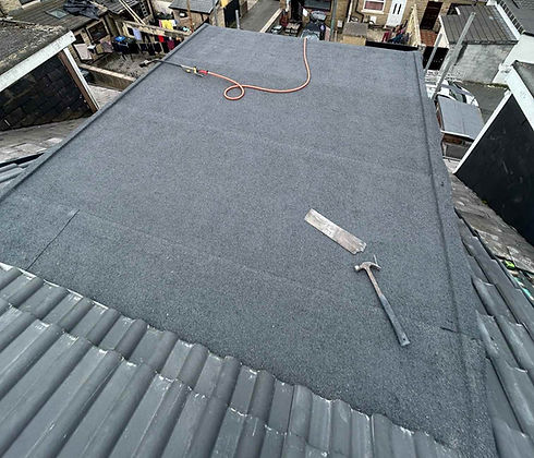 Flat roof with grey felt and tools