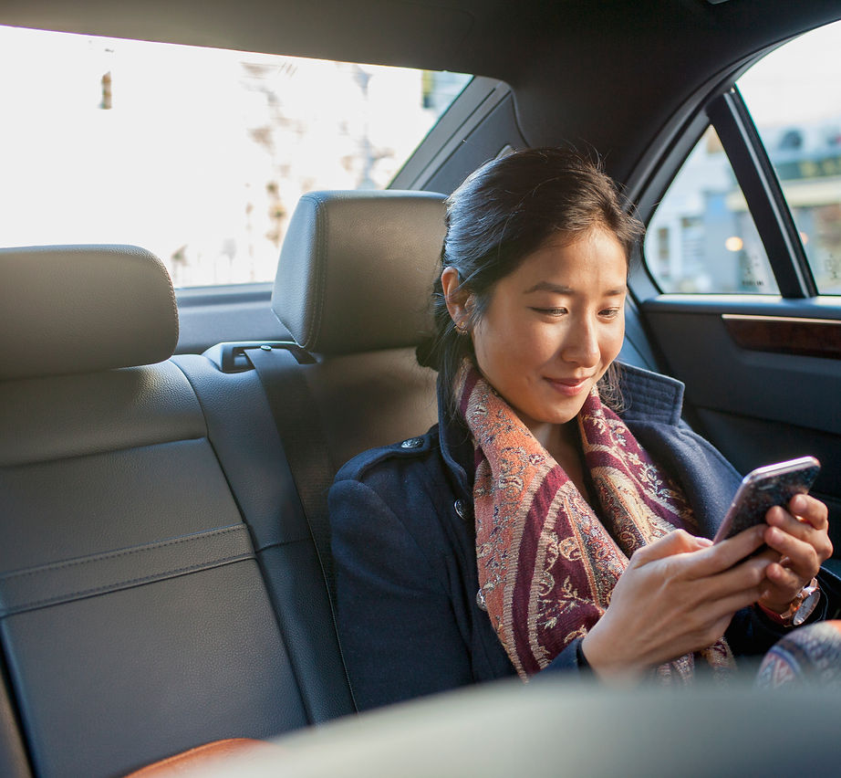 a woman using smartphone inside a taxi