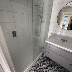 white tiled shower area of a bathroom