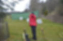 Rear view of a person aiming at a target with a bow and arrow during a practice session