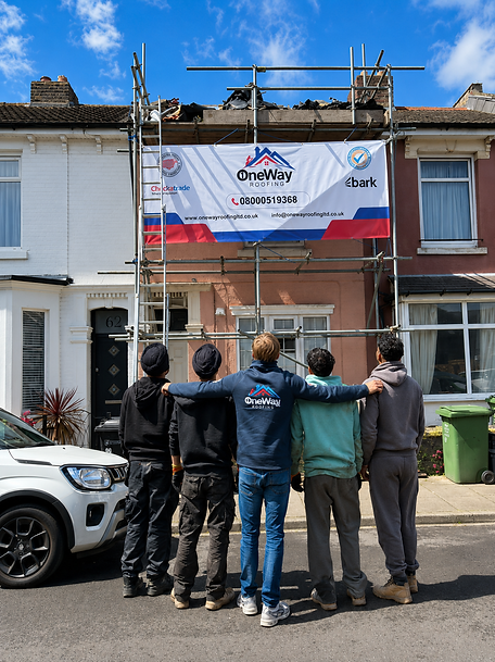 A house with scaffolding and a group of people standing in front of it