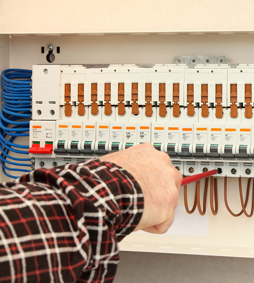 electrican using a tool for inspecting electrical control panel