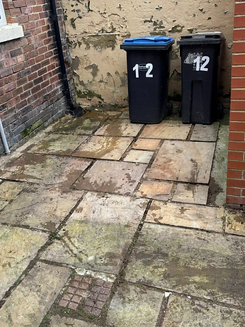 Two numbered bins sit on a worn, tiled patio