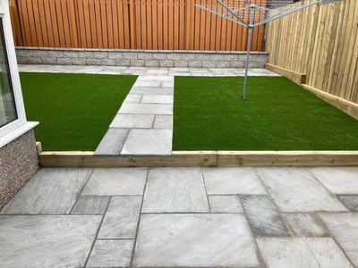 house lawn with green grass surrounded by patio with wooden fence