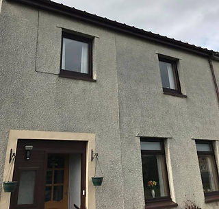 Freshly applied grey roughcast render on an external gable end wall