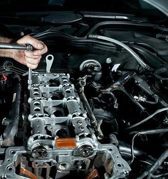 Mechanic repairing engine components using professional tools for vehicle maintenance.